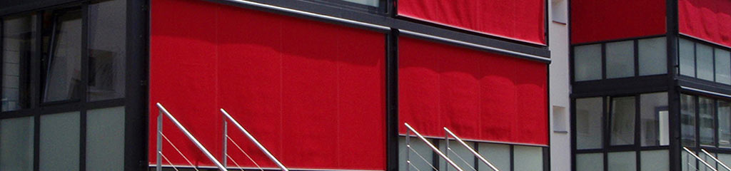 Fensterbeschattung aus roten Stoffrolos